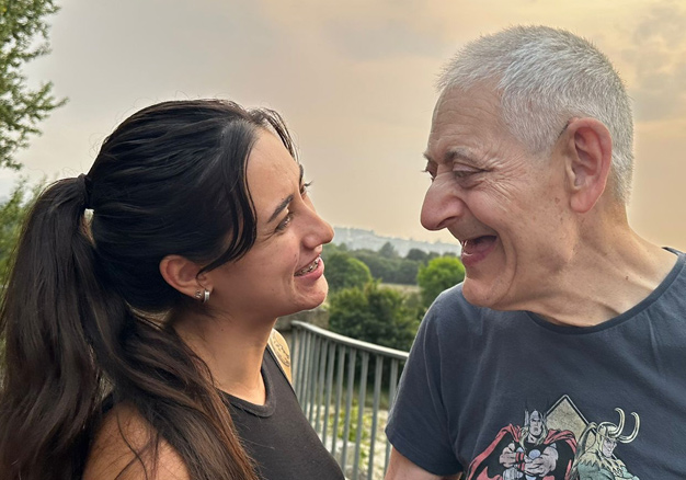 Una persona con discapacidad y su persona de apoyo se miran con cariño y complicidad